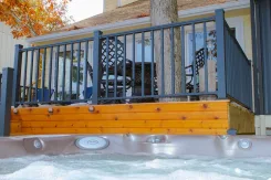 Deck railing beside a hot tub with cedar surround