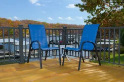 Deck with metal railings and two blue chairs overlooking a lake