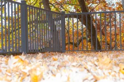 Deck railing with metal balusters among autumn trees