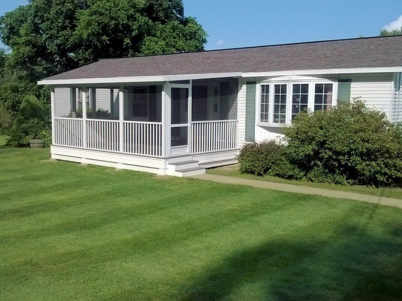 Screened porch with white railings on a single storey house
