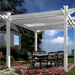 White louvred pergola shading a patio dining set beside a flower bed