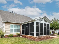 Screened porch with a gabled roof attached to a sided house