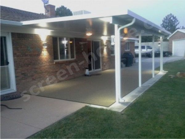 White patio cover over a concrete patio beside a brick house