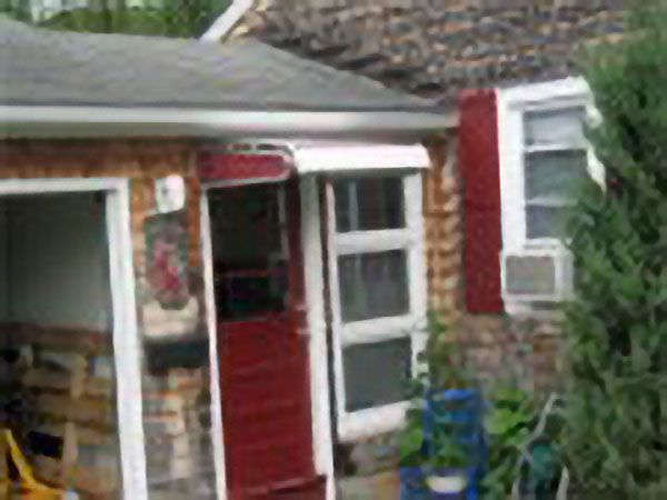 Brick house with red trimmed windows and a storm door