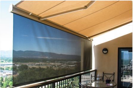 Retractable awning with a solar drop curtain shading a balcony above a valley