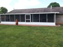 Long screened porch along the back of a single storey house