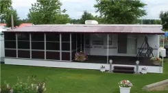 Long screen room with a burgundy roof along the side of a mobile home