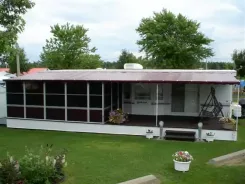 Screen room with a burgundy roof running the length of a mobile home