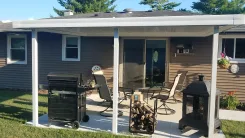White flat pan patio cover over a patio with a barbecue and seating
