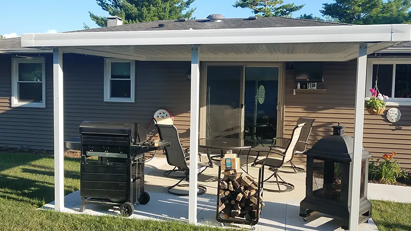 White flat pan patio cover over a patio with a barbecue and seating