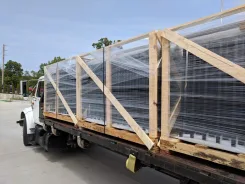 Crated screen wall panels strapped to a flatbed truck for delivery