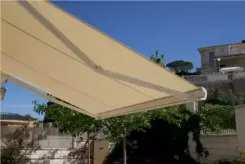 Underside of a cream retractable awning over a garden