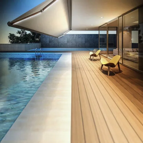 Retractable awning over an indoor pool terrace with loungers