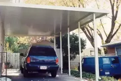 White carport sheltering two cars beside a house