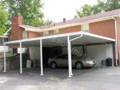 White carport between a brick house and garage with a car parked beneath