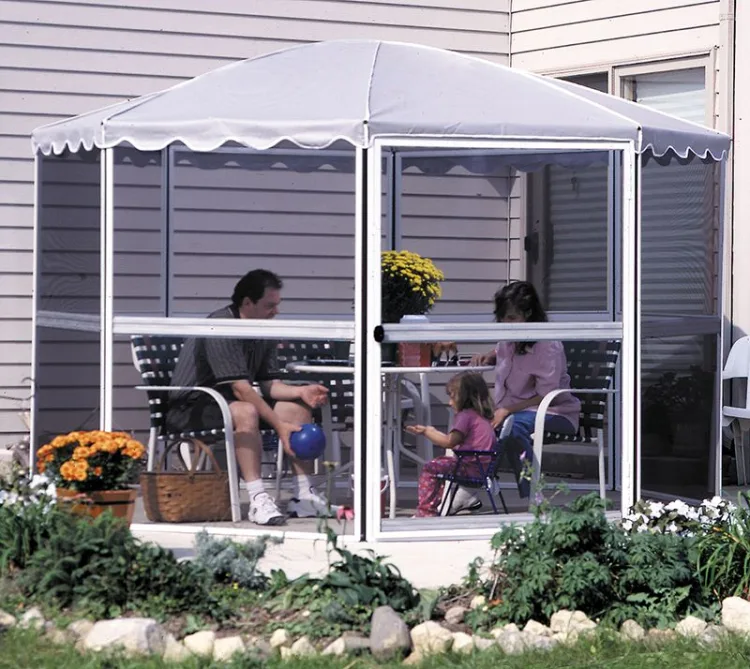 Family seated inside a screen room attached to a house
