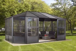 Octagonal screen room with a dark roof and cushioned seating inside, on a lawn