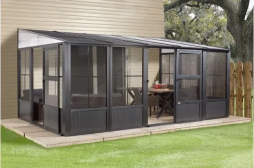 Dark framed sunroom with glass walls on a lawn beside a house