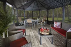 Inside a screen room with wicker seating and a table set with drinks