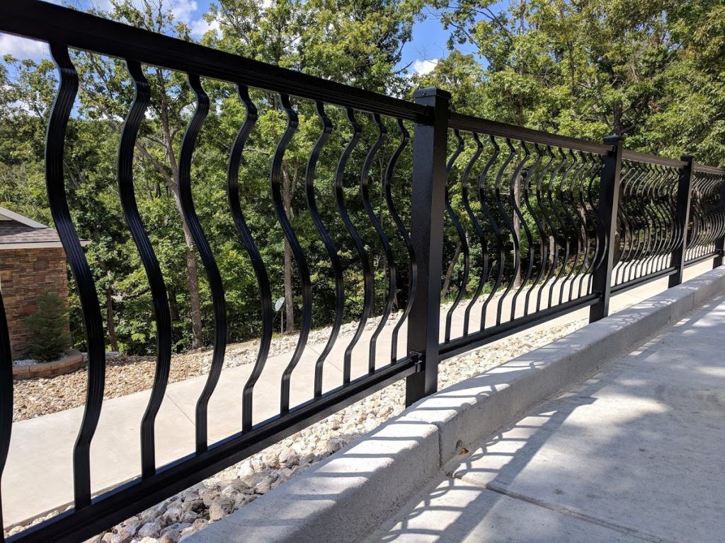 Curved metal balusters along a long deck railing