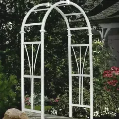 White metal arched arbour with scrollwork panels in a garden