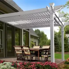 White louvred pergola attached to a house, shading a patio dining set