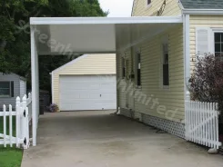 White flat pan carport between a garage and a yellow sided house