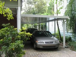 White patio cover over a driveway with a car parked beneath