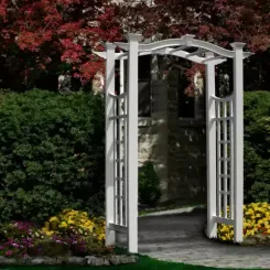 White vinyl arbour with lattice sides in front of a red maple