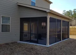 Screened porch along the back of a sided house