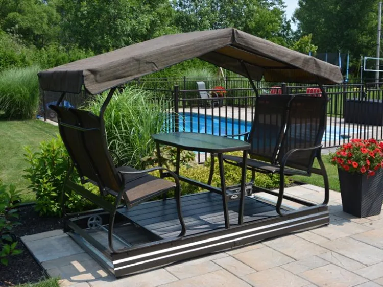 Four seat glider swing with a canopy beside a swimming pool