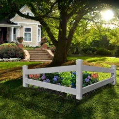 White vinyl picket corner fence around a flower bed beneath a tree