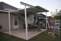 Patio cover installation in progress with ladders on the patio