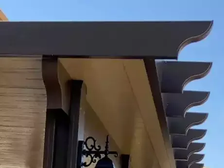 Close-up of a lattice trim edge on a patio cover against a blue sky