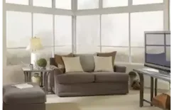 Sunroom interior with lipframe windows, a sofa and television