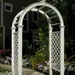 White Livingston arched arbour with lattice sides beside a dark house