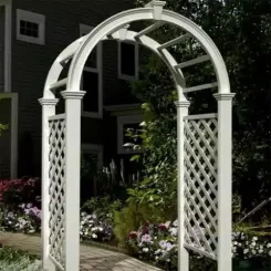 White vinyl arched arbour with lattice sides beside a house