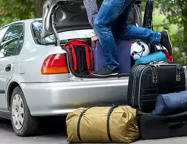 Luggage being loaded into a car boot