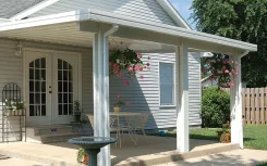 White patio cover over a porch with hanging flower baskets beside French doors