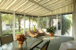 Inside a Polaria screen room with a striped ceiling, loungers and a table