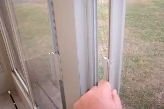 Hand sliding open a polymer window panel on a screen room
