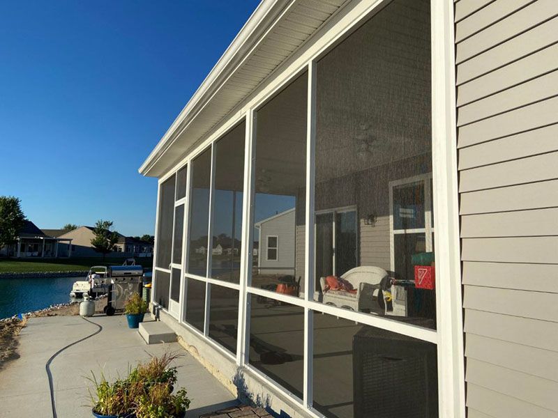 Screened porch along the side of a house overlooking a canal