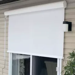 White exterior roller shade lowered over a patio door