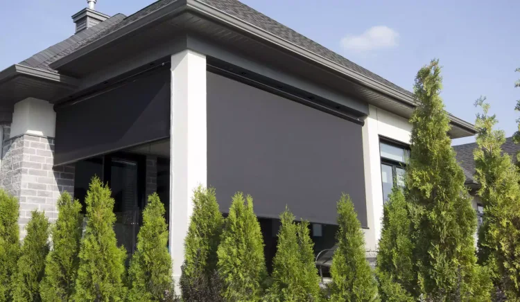 Solar shades lowered across a covered patio of a modern house