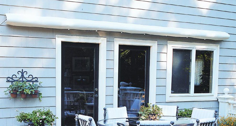 Soft cover awning housing along the back of a blue house