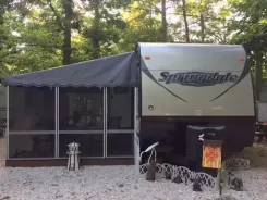 Screen room with a dark canopy roof attached to a Springdale travel trailer