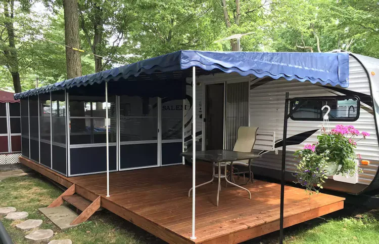 Screen room with a navy awning roof attached to a caravan on a wooden deck