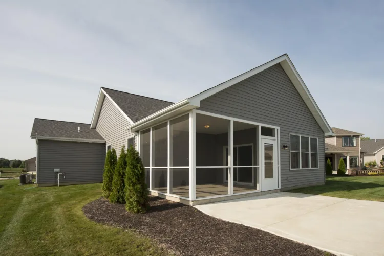 Screened porch with a gabled roof attached to a grey house