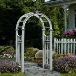 White vinyl arched arbour with lattice sides beside a picket fence