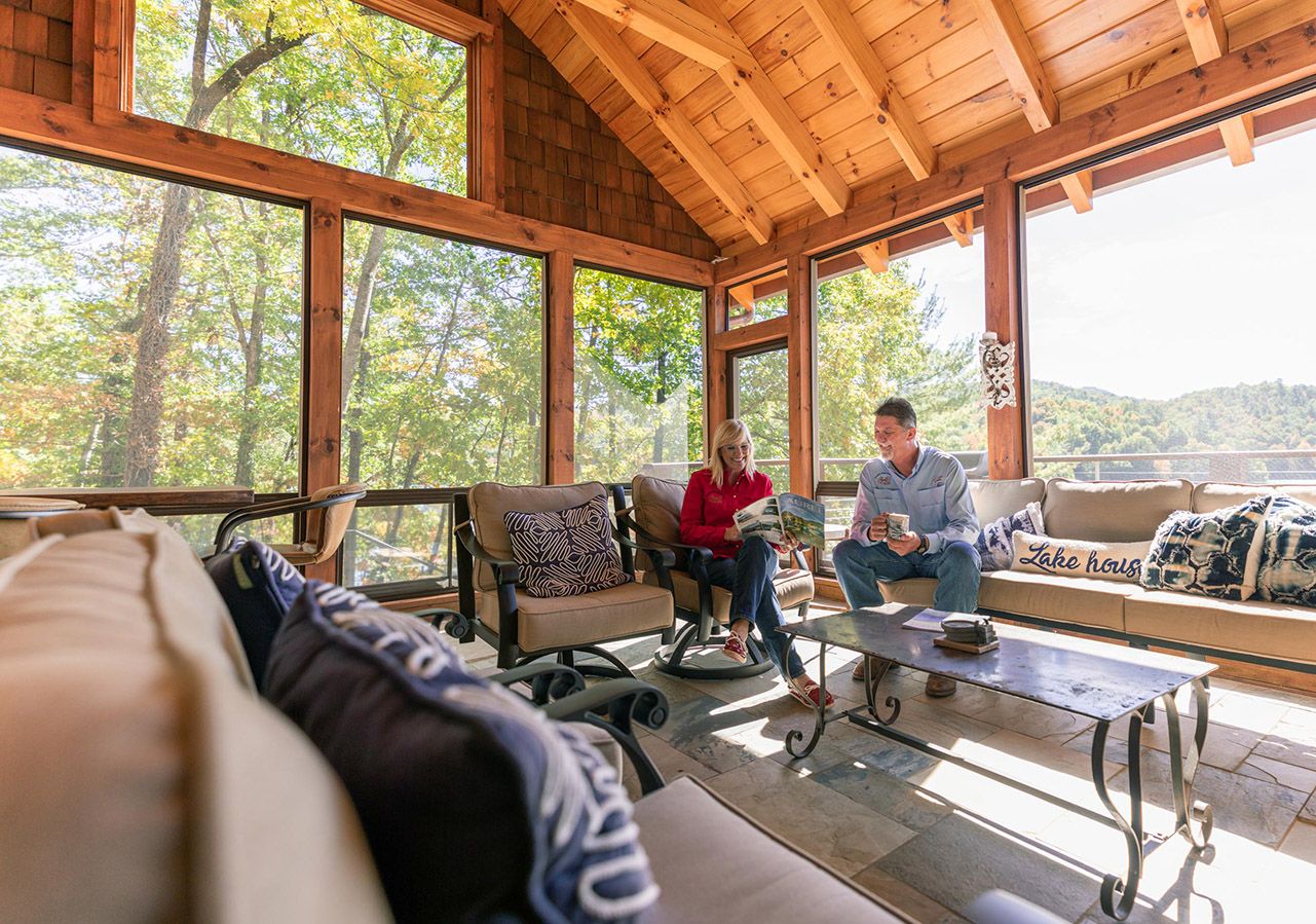 Screened porch interior with a vaulted timber ceiling and two people seated